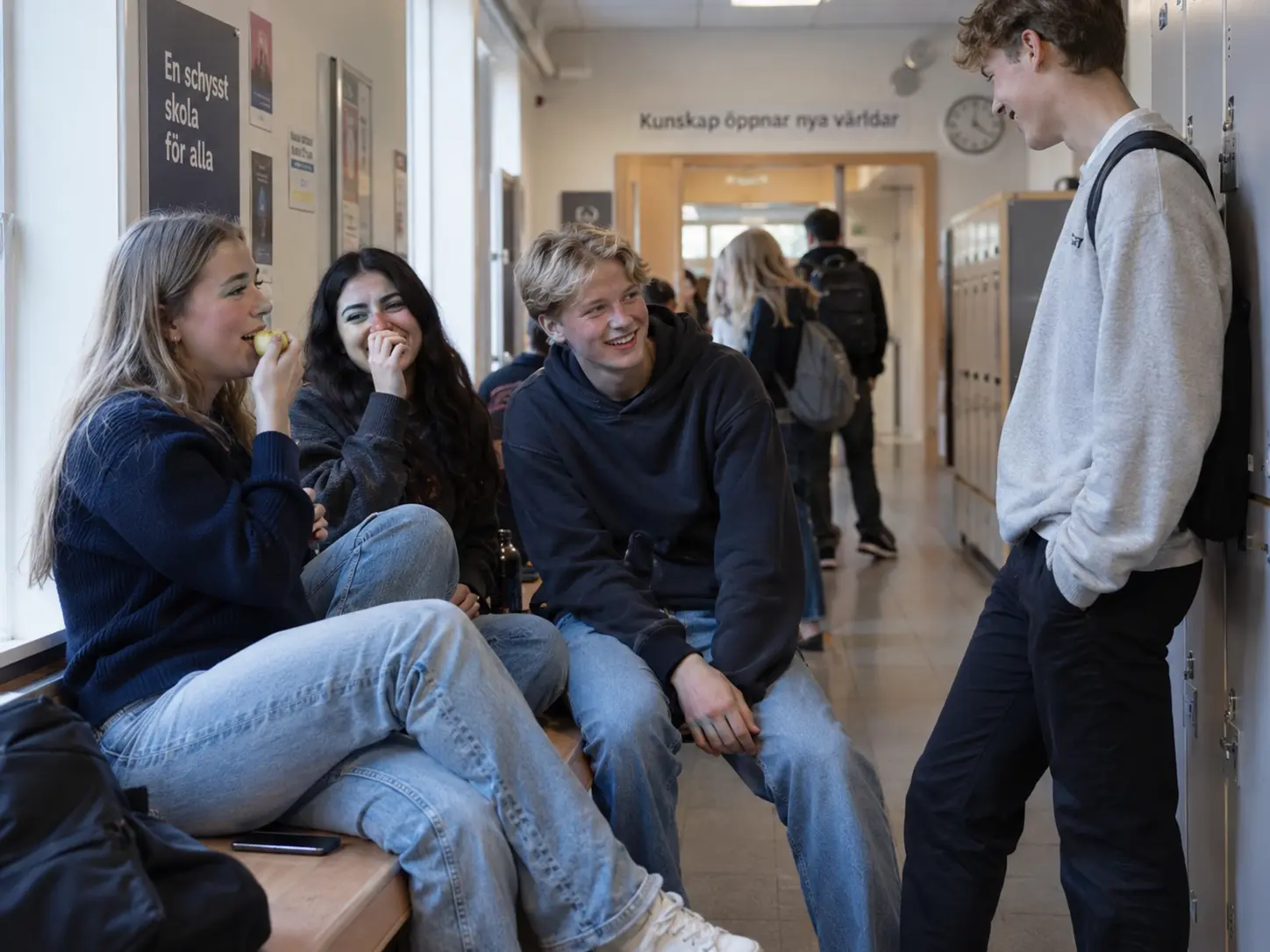 Elever umgås i en skolkorridor medan en mobiltelefon ligger bredvid dem.